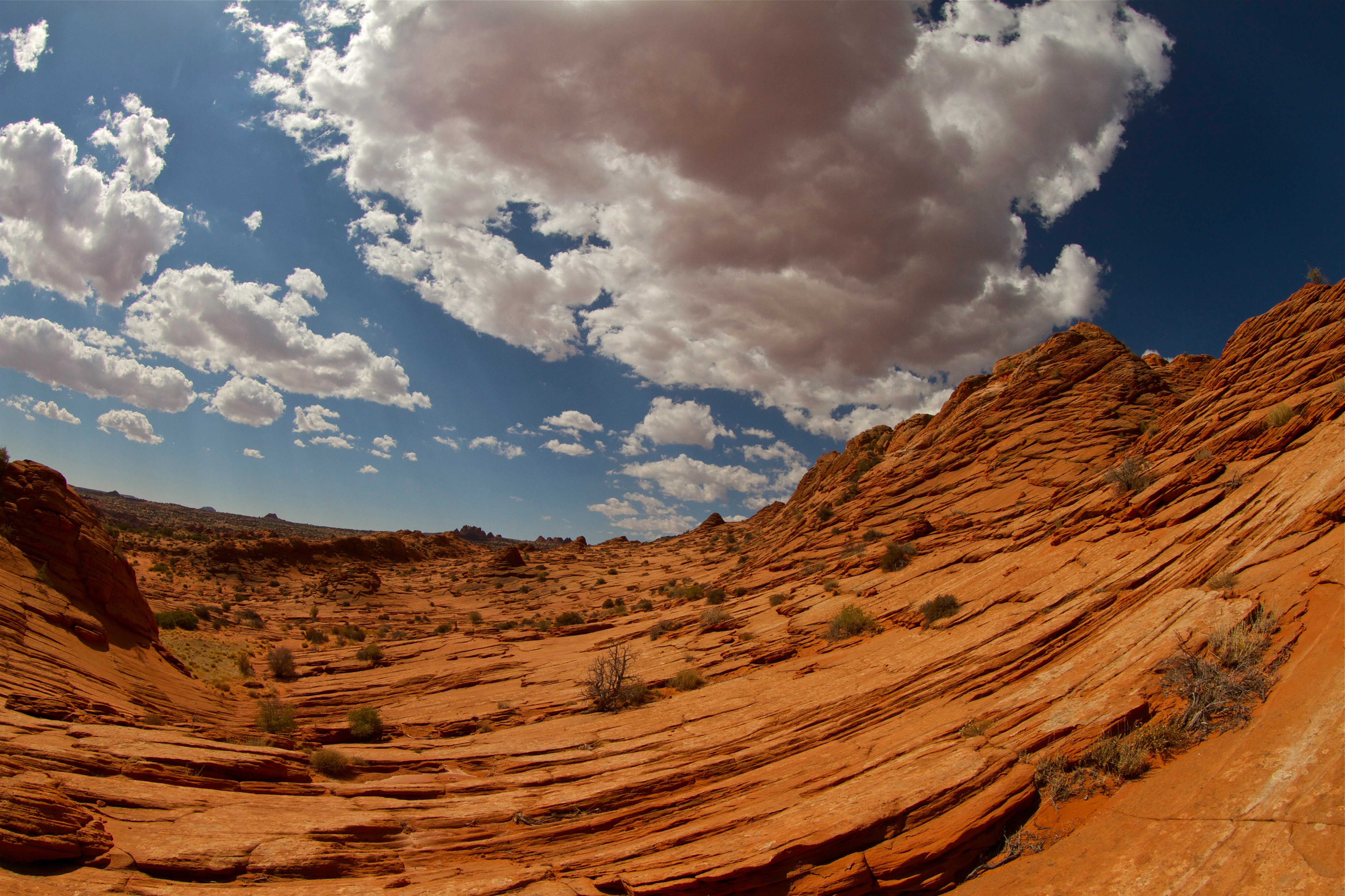 brown rock formation under blue sky and white clouds during daytime